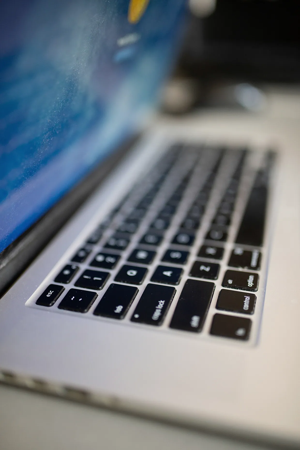 Close-up view of a laptop keyboard while in use, showcasing detailed key layout and lighting effects